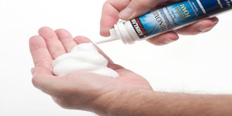 Picture of a man putting minoxidil foam on his hand.