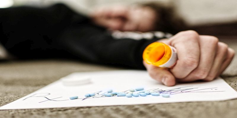 Image of someone who took an overdose of pills lying on the ground.