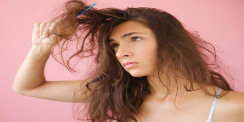 A woman holding her hair while looking sad.