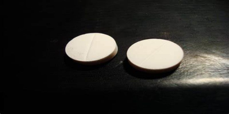 Image of two white pills lying on a table.
