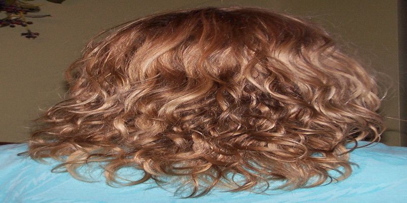 Image of the rearview of a woman's curly hair.